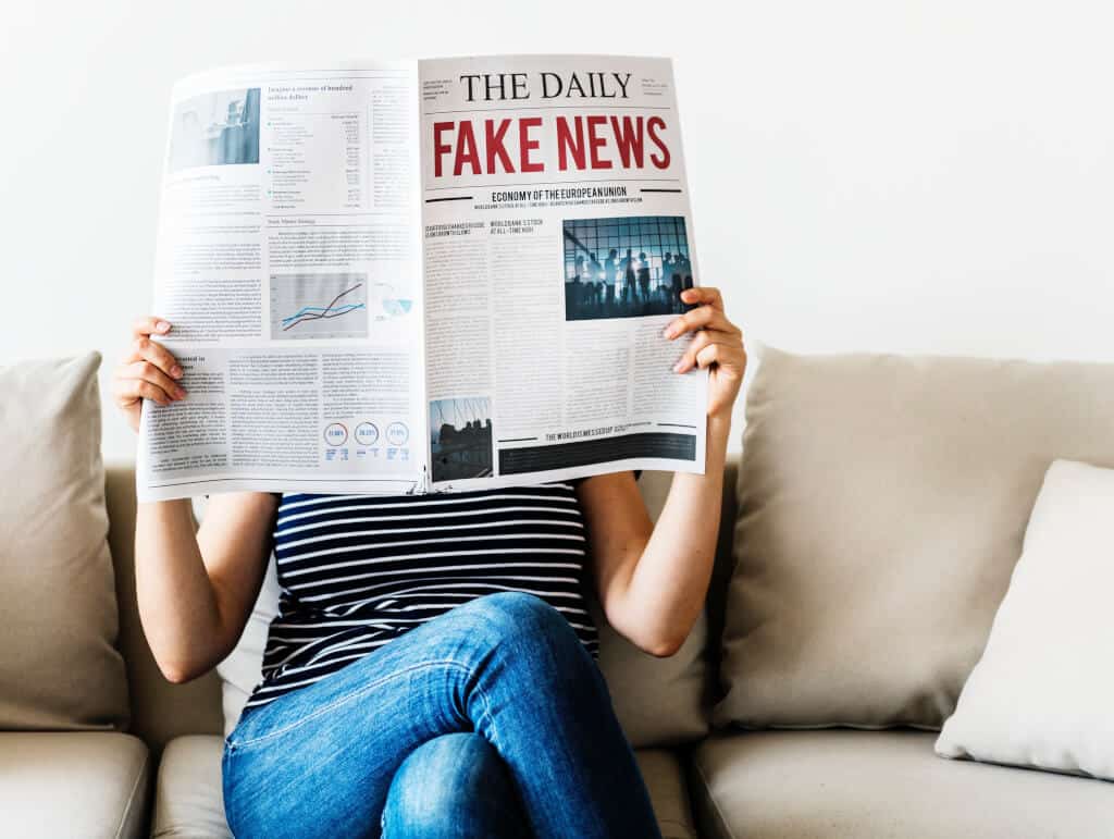 Woman reading fake news newspaper