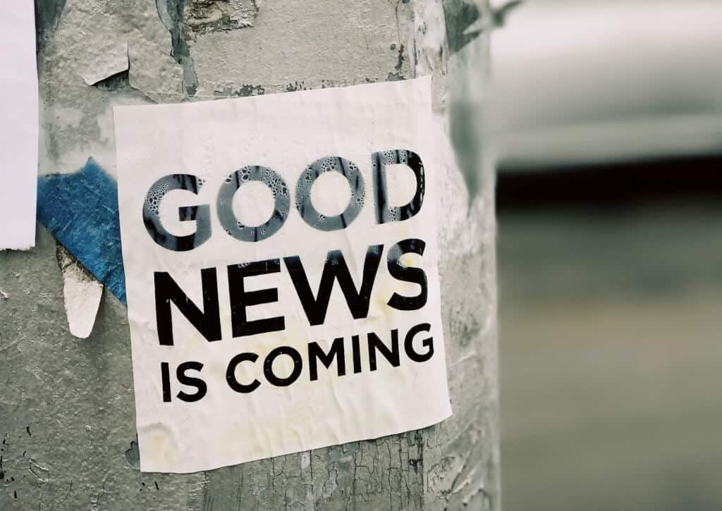 good news is coming, sign on lamp post
