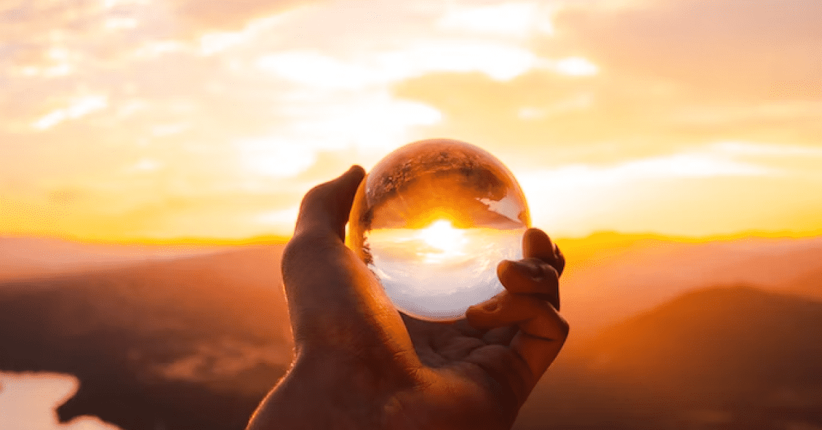 A person holding a crystal ball up to the sky